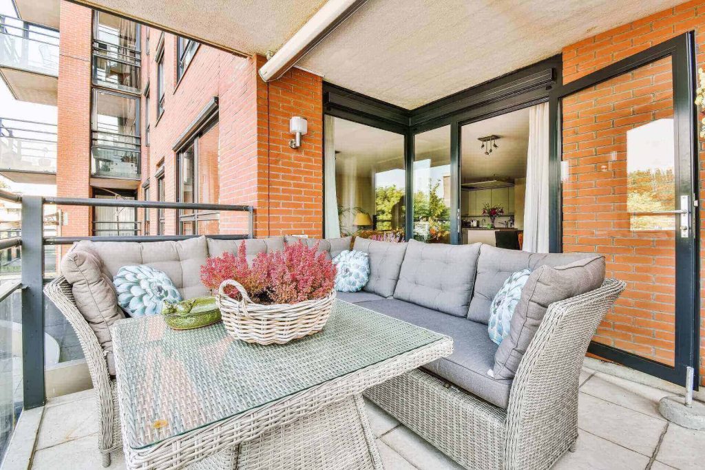 Balcony with a wicker lounge set and flowers