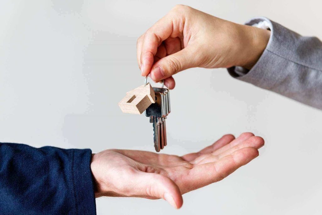 Agent handing house keys to a new homeowner