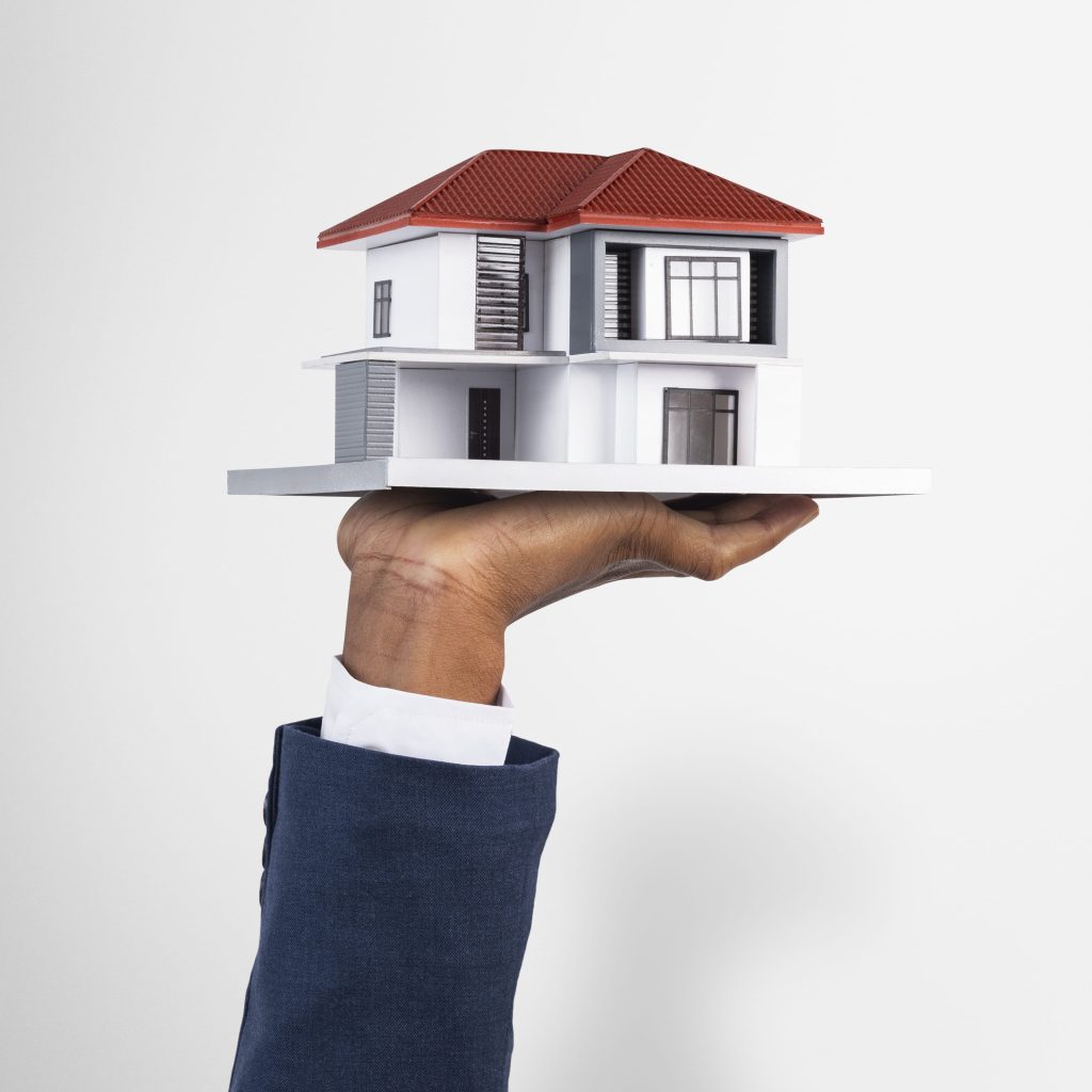 Hand holding a model house