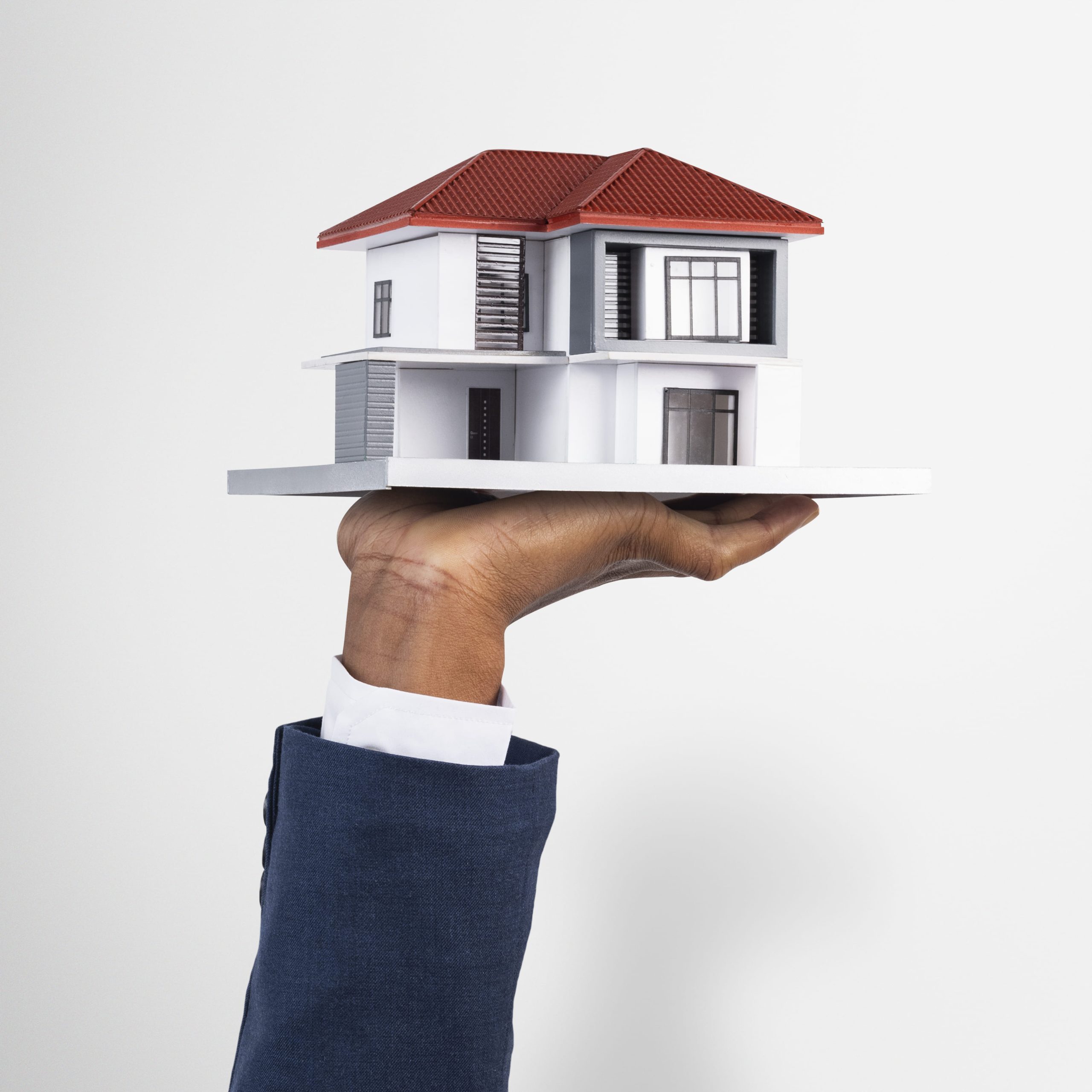 Hand holding a model house